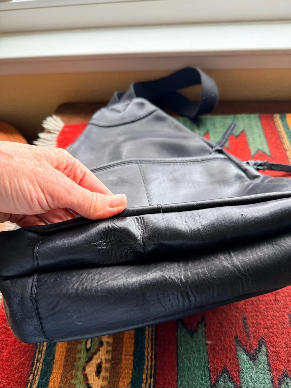 Black trianglular leather backpack with multiple pockets